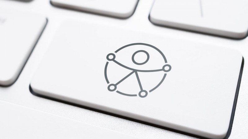Tecla de computador com o símbolo universal da acessibilidade, que é uma pessoa estilizada dentro de um círculo.